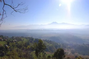 Panoramic view from Phulchoki Hill near Kathmandu with lush valley, forest hills, and distant Himalayan range