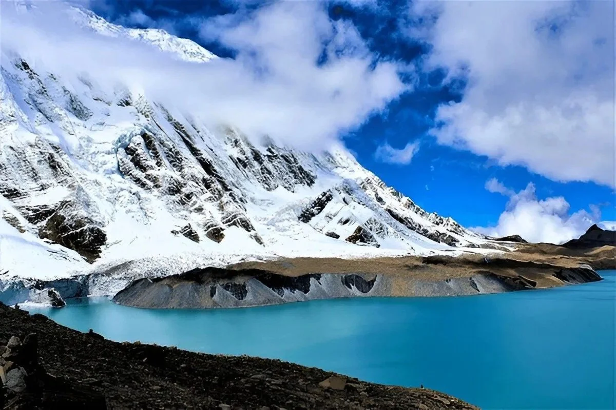 Tilicho Lake with turquoise water and snow-covered Himalayan mountains in the Annapurna region