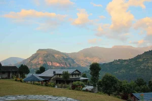 Beautiful view of Dhampus Village featuring traditional stone houses, lush green hills, and peaceful mountain landscapes beneath a colorful evening sky in Nepal.